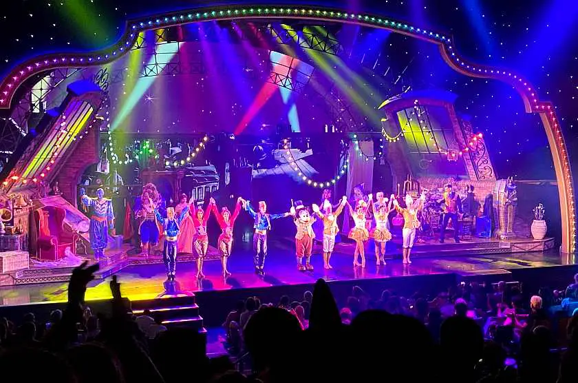 Mickey and other dancers in disney costume on a rainbow light stage taking a final bow at the Animagique show at Disneyland Paris studios