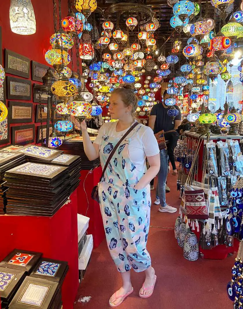 Mel looking at colourful hanging lanterns in a souvenir shop