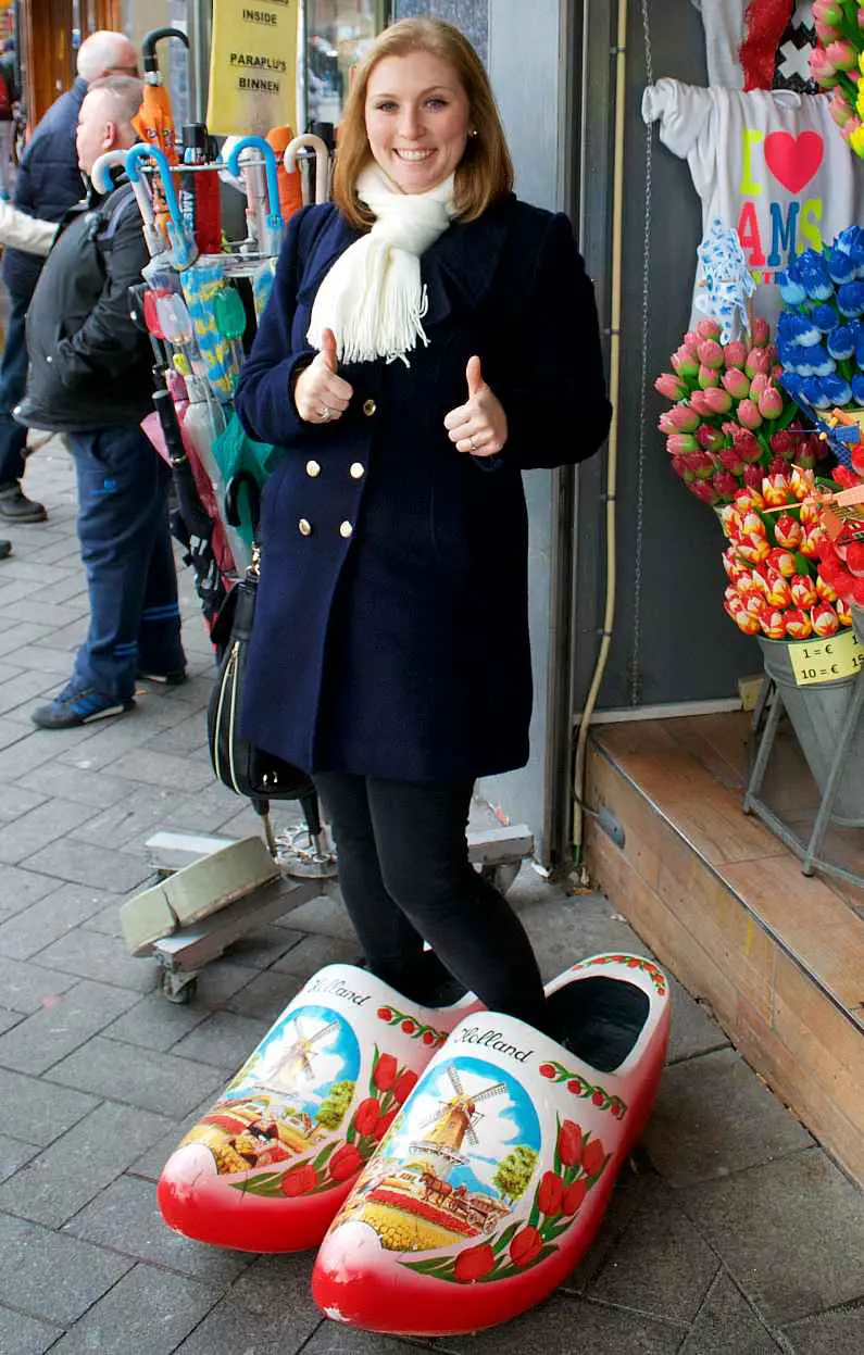 Mel stood in giant clogs and giving a thumbs up in Amsterdam