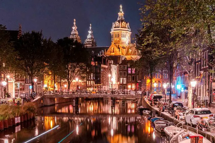 Amsterdam's red light district at night alongside the canal