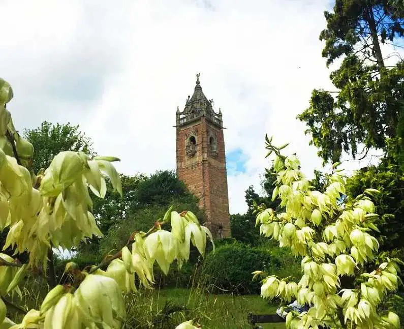 Cabot Tower, a Victorian brick tower in the middle of a green park filled with flowers