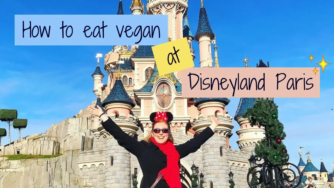 mel with arms stretched up in front of disneyland paris castle, how to eat vegan at disneyland paris