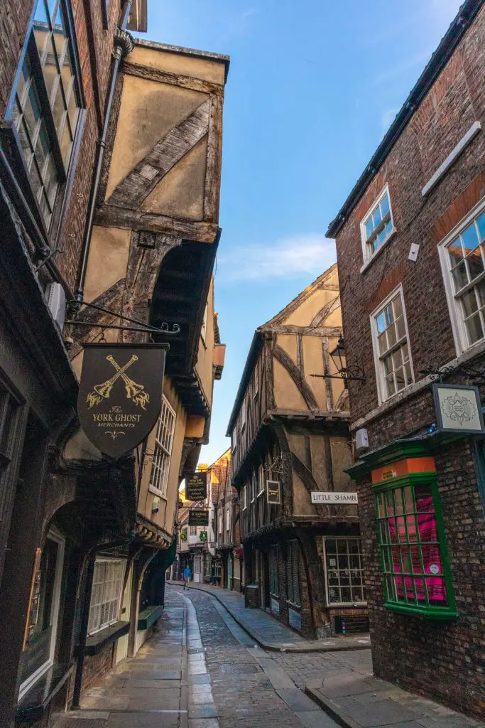 Medieval main street in York, UK with brown facades, windows and signs