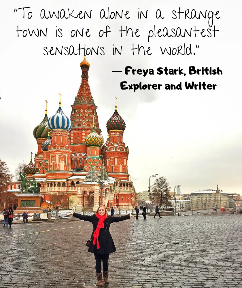 Mel holding her arms out in front of the Saint Basil's Cathedral in Red Square Moscow with the quote “To awaken alone in a strange town is one of the pleasantest sensations in the world.” by Freya Stark, British Explorer and Writer 