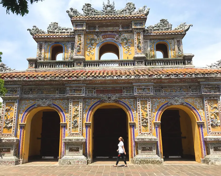 Mel from Footsteps on the Globe walking in front of the Imperial Palace in Hue in Vietnam