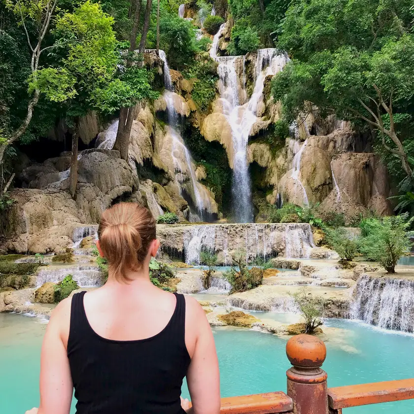 Mel from Footsteps on the Globe stood in front of a waterfall in Luang Prabang in Laos, Breaking up, backpacking and beginning again 