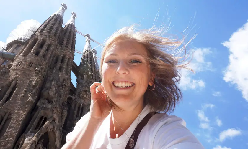 Mel from Footsteps on the Globe smiling in front of the Sagrada Familia in Barcelona Spain with a sunny blue sky, a year off blogging, Why I took a year off blogging: Breaking up, backpacking and beginning again