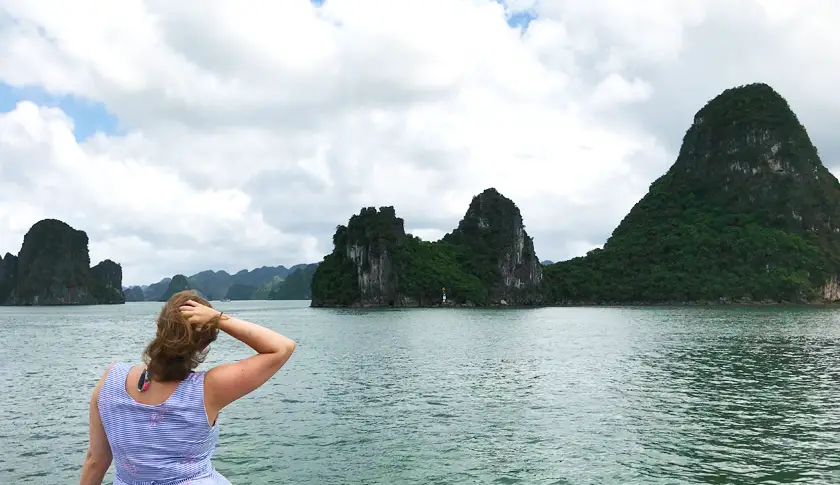 Mel from Footsteps on the Globe in Halong Bay in Ha Long City in Vietnam with a sunny blue sky and mountains