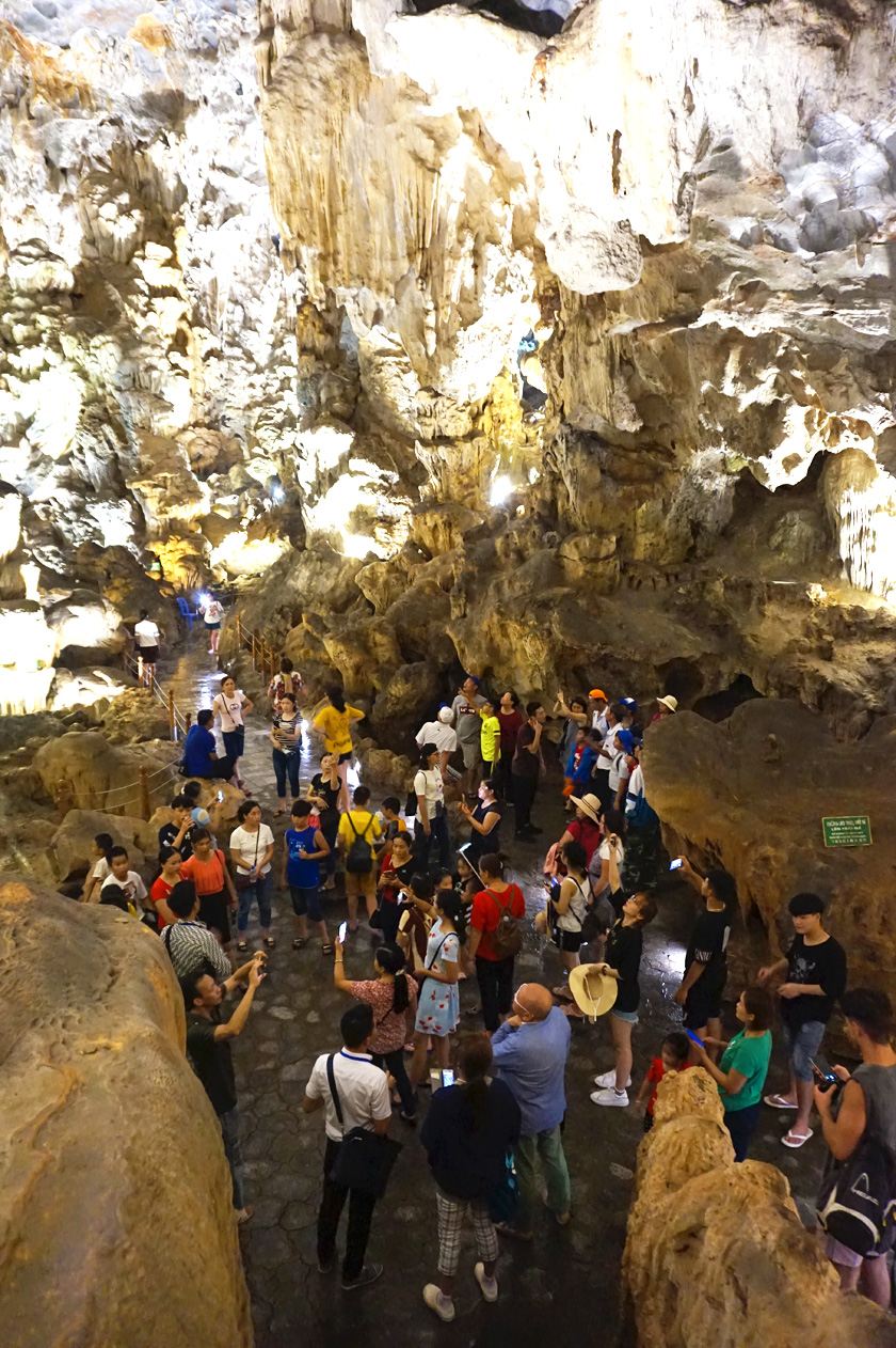 Inside a cave in Halong Bay in Vietnam with a crowd of people