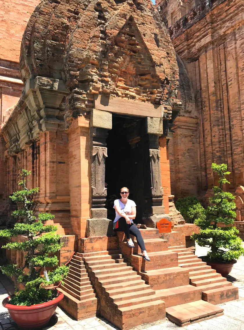 Mel from Footsteps on the Globe sat at the entrance of one of the temples at Ponagar Towers in Nha Trang in Vietnam