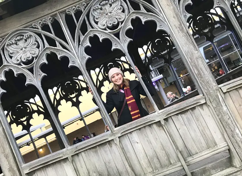 Mel from Footsteps on the Globe on smiling from the window of the Hogwarts Bridge