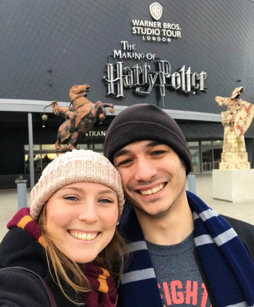 Mel from Footsteps on the Globe and her boyfriend smiling outside the front of the Harry Potter Studios London 