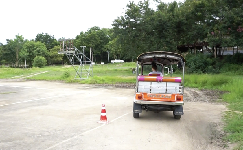 Mel from Footsteps on the Globe driving a Tuk Tuk around a cone at the Tuk Tuk test centre