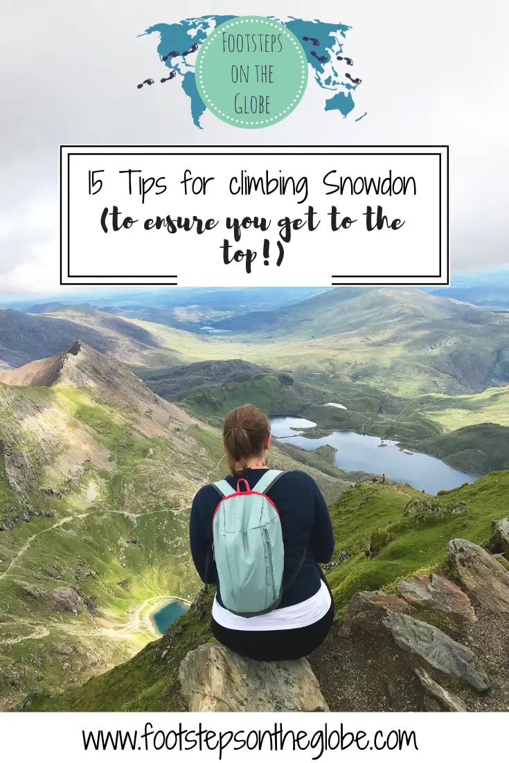 Mel sat on a rock with her back to the camera with her backpack on at the top of Snowdon looking out onto the horizon with green hills and blue lakes in the background - Pinterest image.