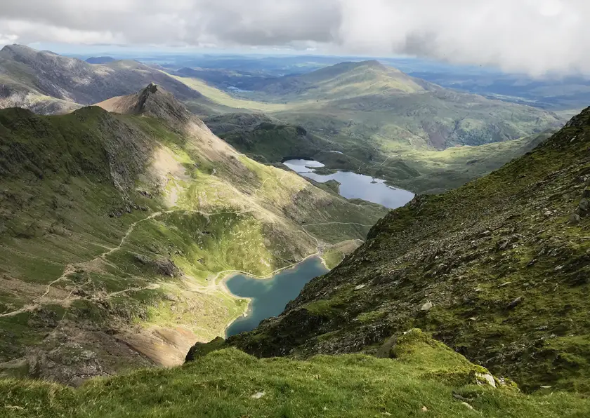 Landscape view from the top of Snowdon with green hills, lakes and clouds. 