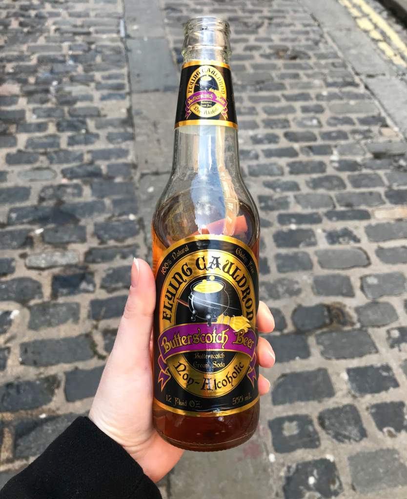 Mel holding a bottle of butterbeer down The Shambles street in York