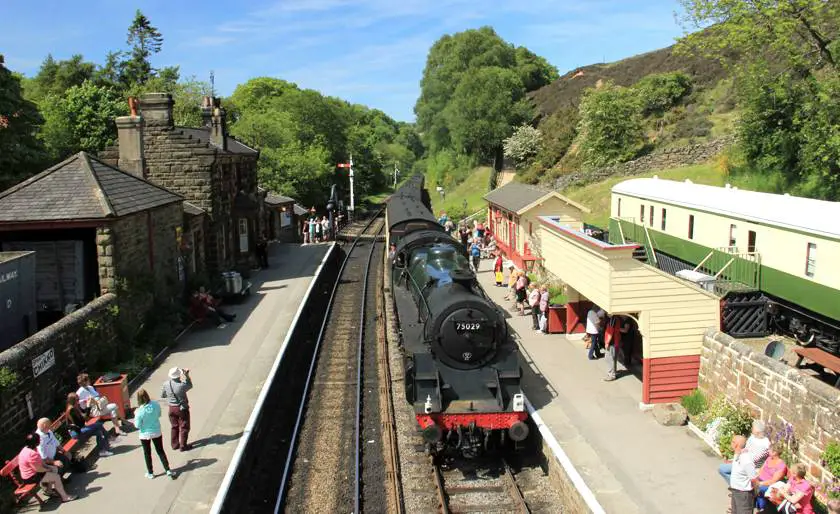 Goathland Railway Station in Yorkshire with an old fashioned locomotive on the tracks which was the location of Hogsmead in Harry Potter and the Philospher's Stone