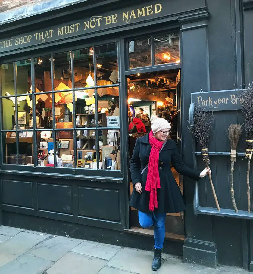 Mel stepping out of the 'Shop that must not be named' grabbing a broom from outside down The Shambles in York