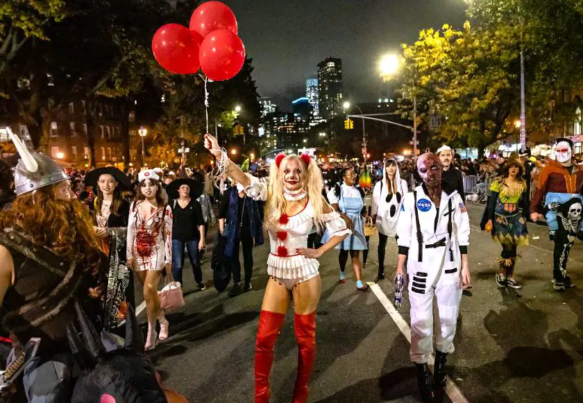 People dressed in Halloween costumes in New York with a woman dressed as the clown from 'IT' at the forefront of the picture