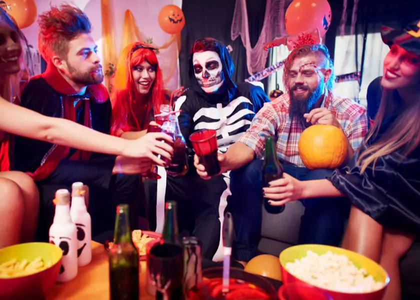 People dressed up at a halloween party saying cheers 