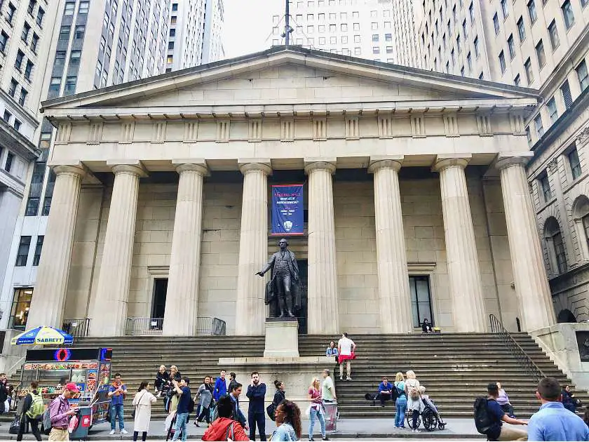 Outside the Federal Hall in New York - with columns and tall steps and a George Washington statue outside