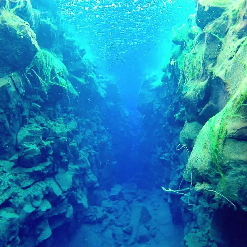 View of swimming between tectonic plates in Iceland through a rock gorge
