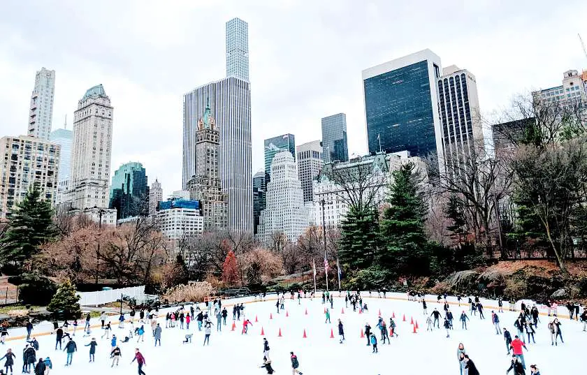 People ice skating in New York's Central Park surrounded by skyscrapers