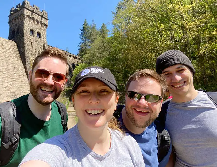 Mel and friends smiling during a hike on a sunny day