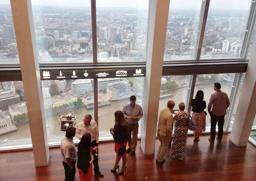 People looking out of the window at The Shard looking over the skyline of London