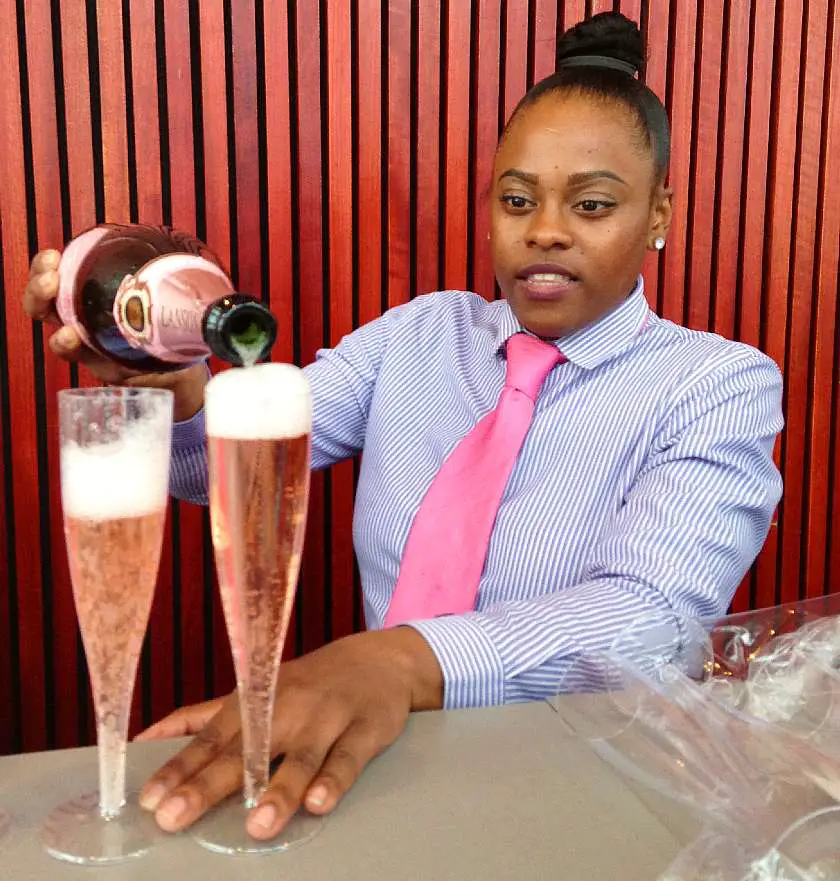 Waitress pouring pink champagne from behind the bar at The Shard