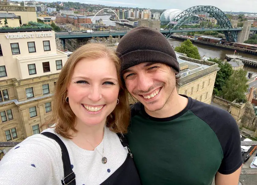 Mel and her boyfriend Joe smiling with the Newcastle skyline in the background and the Tyne Bridge