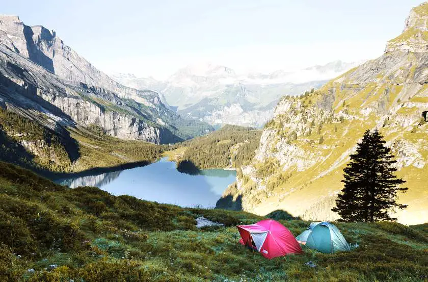 Two tents wild camping with mountains and a lake in the background