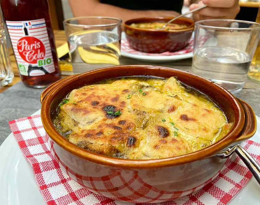 Vegan french onion soup on a red chequered napkin in Paris