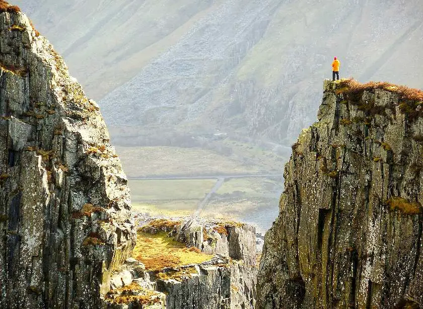 Man stood on top of Dinorwic quarry with the valley in the background