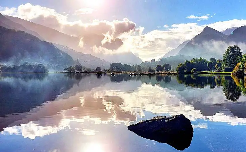 Lake Padarn with a still glossy water top and blue skies