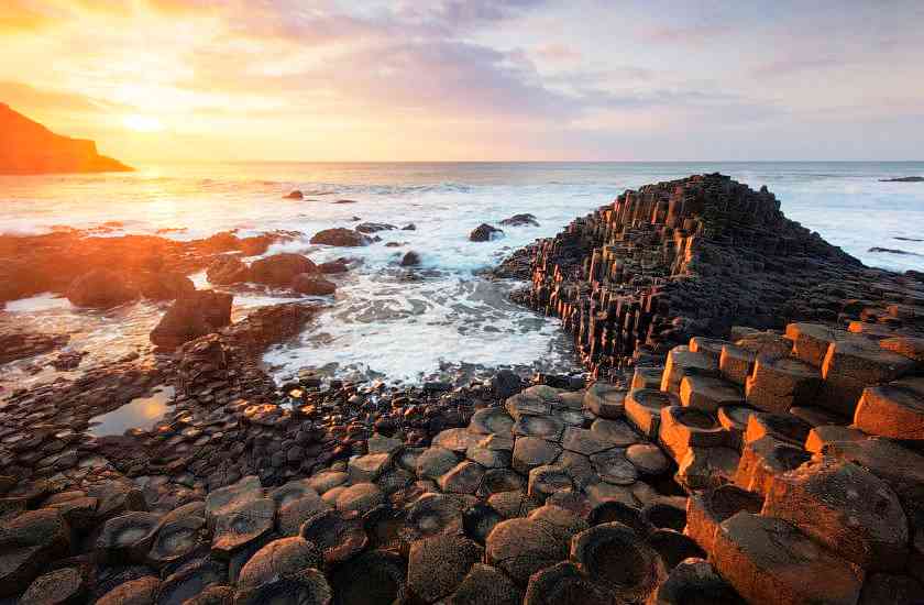 The Giant's Causeway at sunset with stones and waves in the background