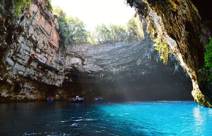 Melissani Lake in Kefalonia, a cave with a collapsed top with sunlight shining into the bright blue water