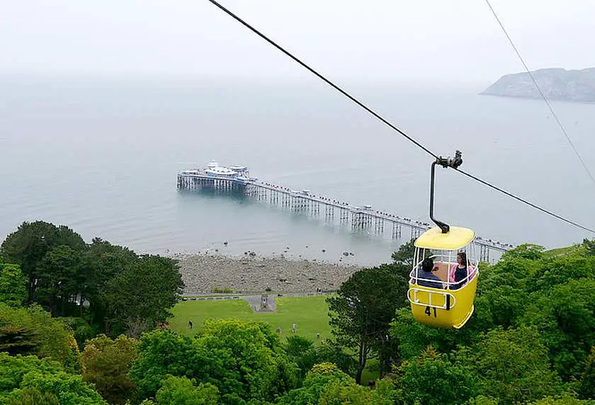 Yellow cable car with Llandudno pier in the background
