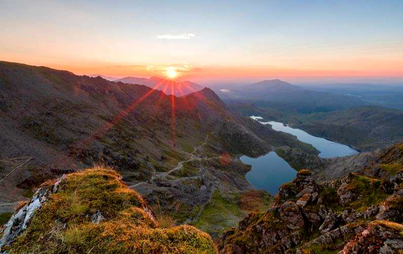 View from Snowdon's summit as the sun comes up red over the mountains