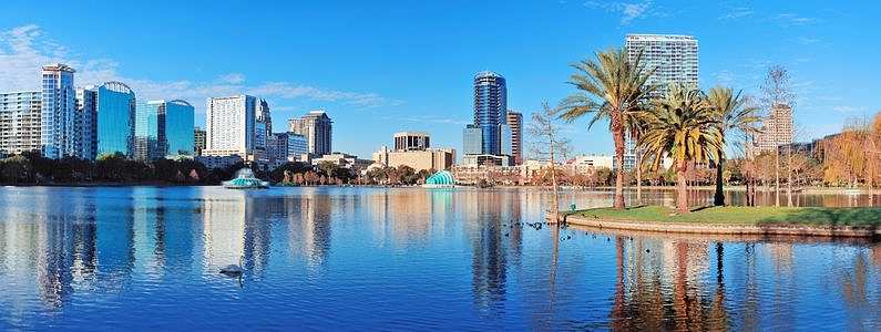 Eola Lake in Orlando, Florida with palm trees and buildings in the background 