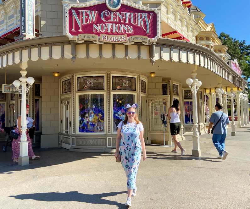 Mel walking down Main Street in Disneyland Paris with "Flora's Boutique" in the background