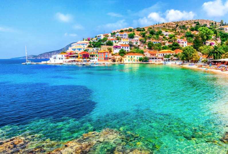 Assos village in Kefalonia with colourful villas around a beach cove and blue water