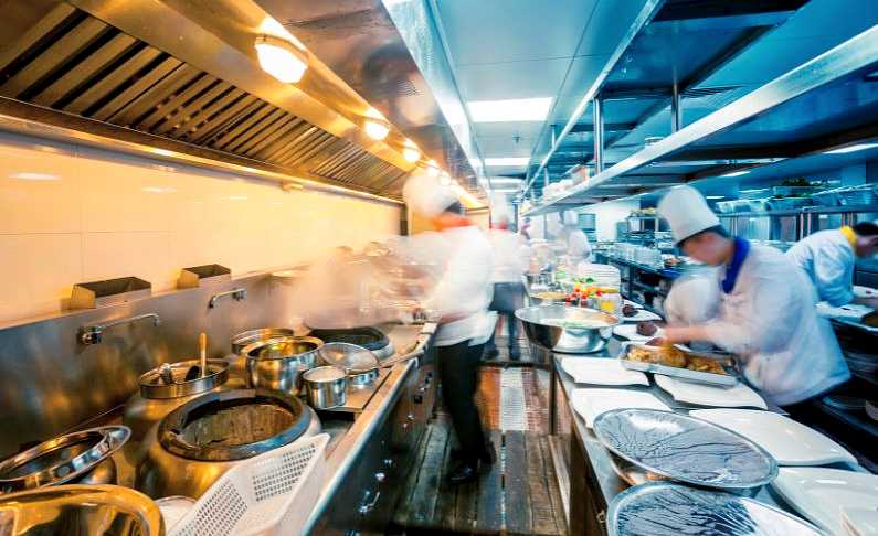 Inside a busy restaurant kitchen with chefs preparing food
