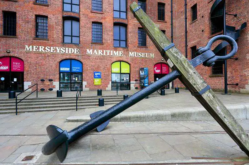 Front of the Merseyside Maritime Museum, a red brick industrial building with a giant anchor outside 