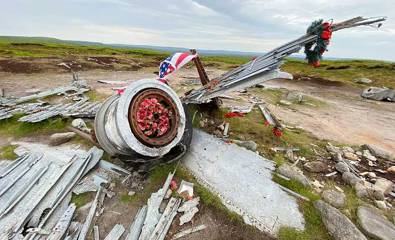 Crashed B29 plane engine with an American flag and red poppy wreath around it
