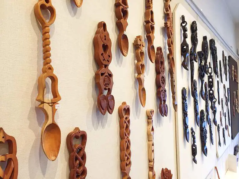 Rows of hand-carved Welsh love spoons on a wall in a shop in Swansea Bay