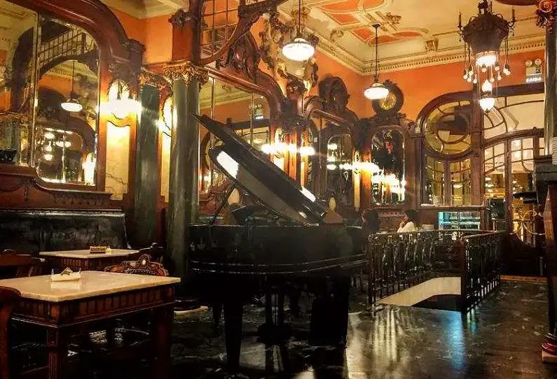 Inside the Majestic Café, a turn of the century grand cafe with decorative light fixtures and a grand piano