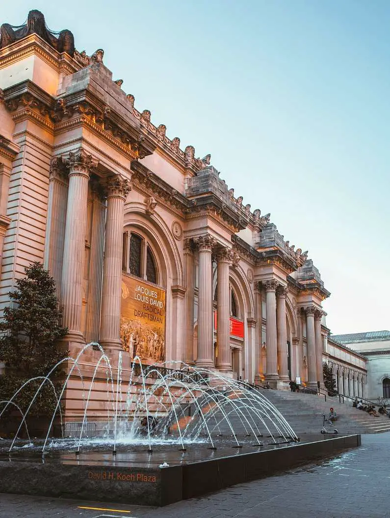 The Metropolitan Museum of Art in New York, a white neo-classic building with a fountain outside