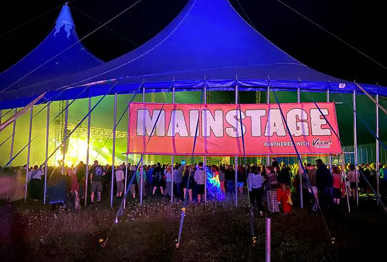 Main stage of Vegan Camp Out at night with a crowd of party goers and bright lights