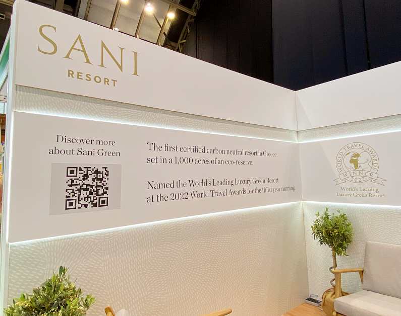 Sani Resort all-white stand with the text: "The first certified carbon neutral resort in Greece set in a 1,000 acres of an eco-reserve. Names the World's leading luxury Green Resort at the 2022 World Travel Awards for the third year running"